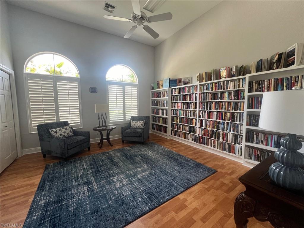 Library/Sitting room featuring a towering ceiling and wood-type flooring