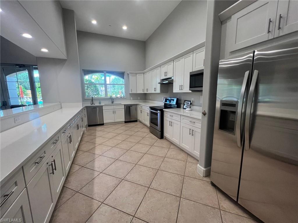 Kitchen featuring stainless steel appliances, white cabinets, sink, and light tile floors