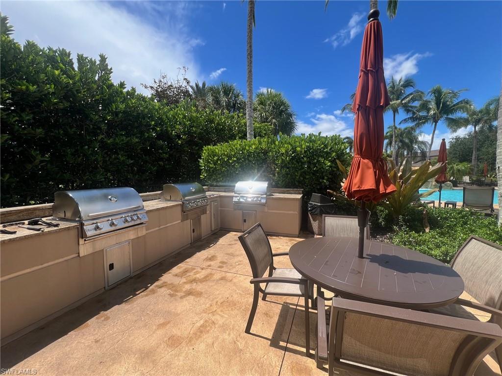 View of community pool patio / terrace with a pool, a grill, and exterior kitchen