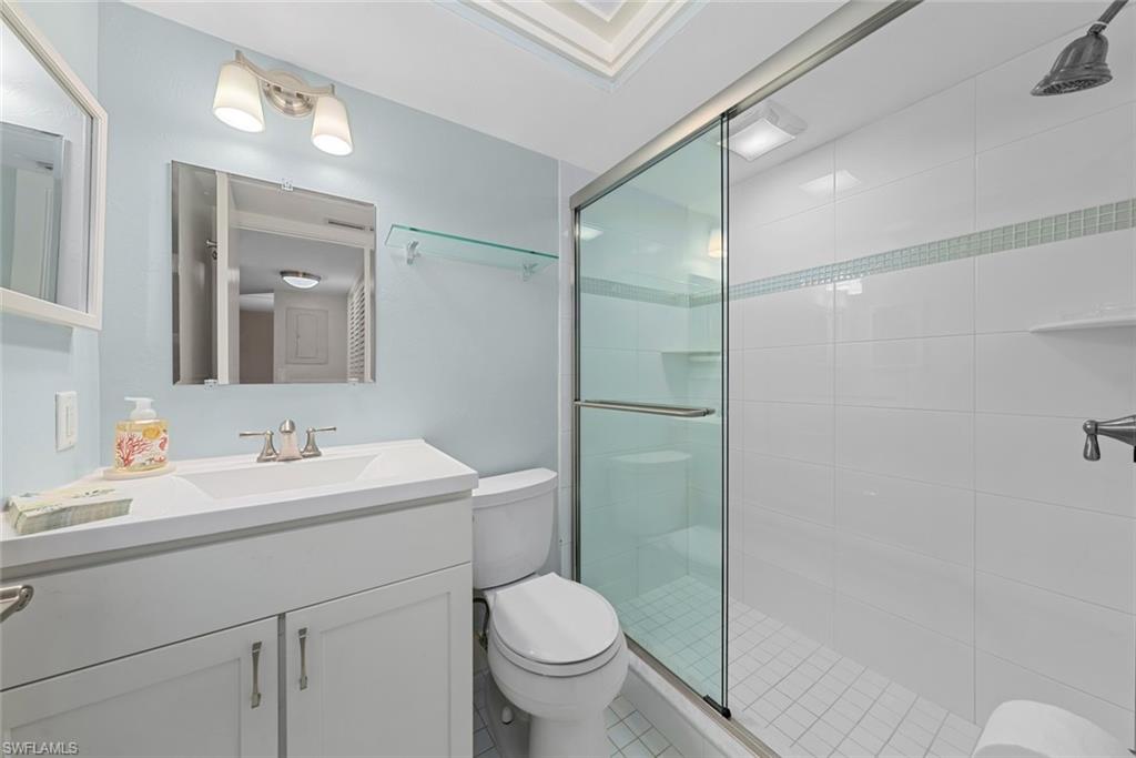 Bathroom featuring a white vanity with integrated sink, chrome faucet, and mirrored medicine cabinet