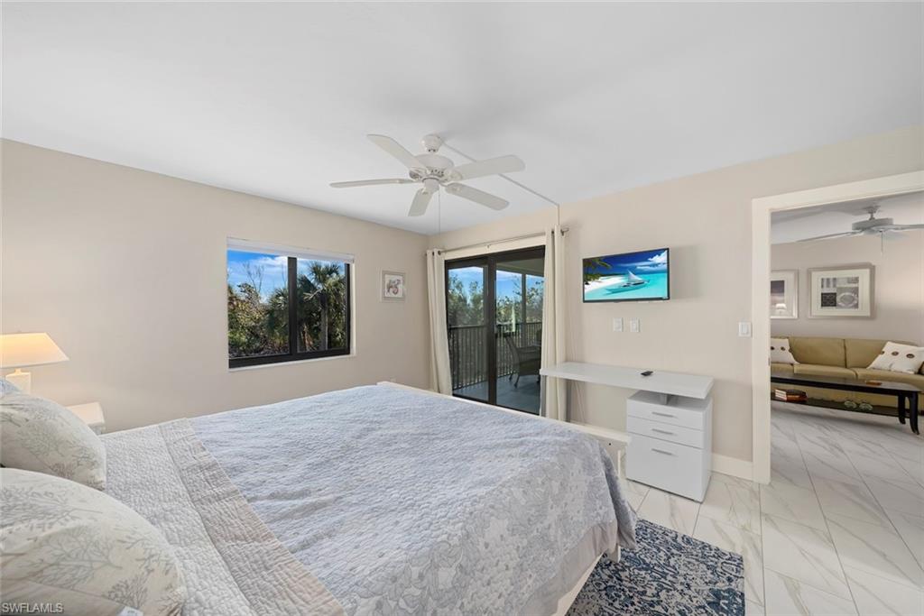 Bedroom featuring a private balcony access, ceiling fan, and white tile flooring