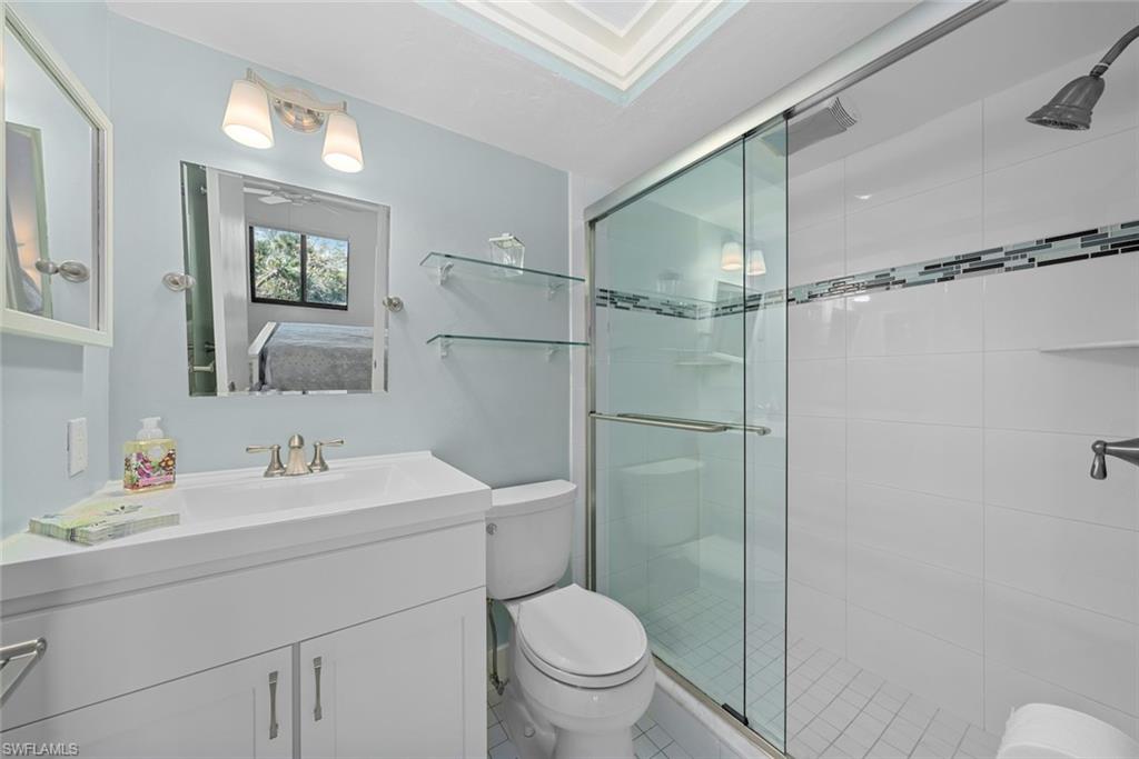 Full bathroom featuring a white vanity with integrated sink, brushed nickel faucet, and overhead lighting