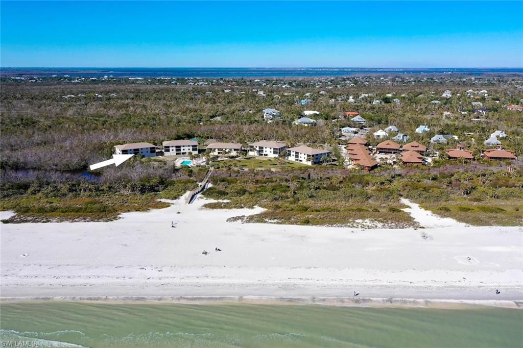 Coastal property featuring a white sand beach and verdant foliage