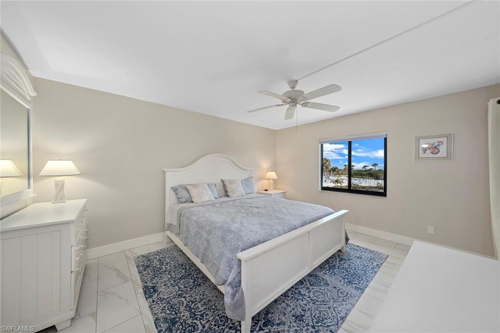 Bedroom featuring a ceiling fan, a window with exterior scenery, and light-toned walls