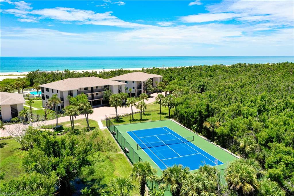 Tennis court with blue playing surface and green surrounds