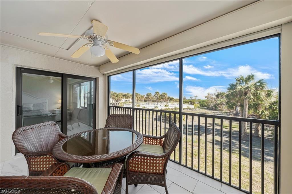 Screened balcony featuring white tiled flooring and an overhead ceiling fan