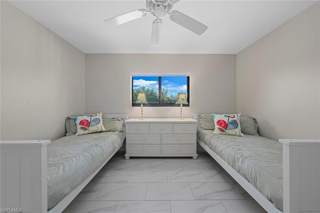 Recessed window with exterior scenery, white ceiling fan with integrated lighting, light gray wall paint, and large format white tile flooring