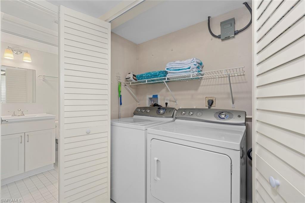 Dedicated laundry area featuring a full-sized washer and dryer, wire shelving, and a louvered bi-fold door