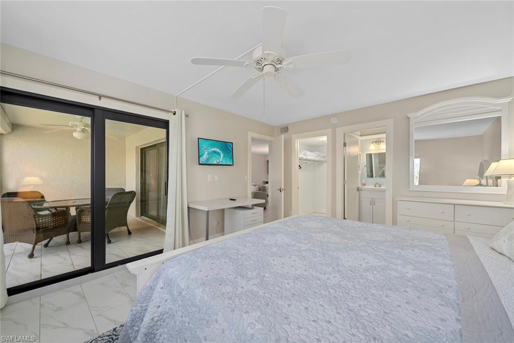 Spacious room featuring large sliding glass doors opening to an outdoor patio with tiled flooring and a ceiling fan