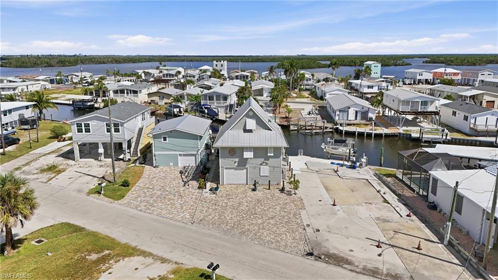 Waterfront property featuring a distinctive light grey exterior with a gabled roofline