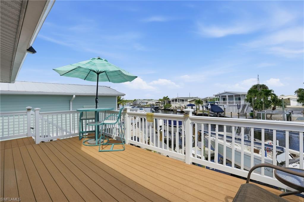 Expansive outdoor deck featuring wood-finish flooring and white railing