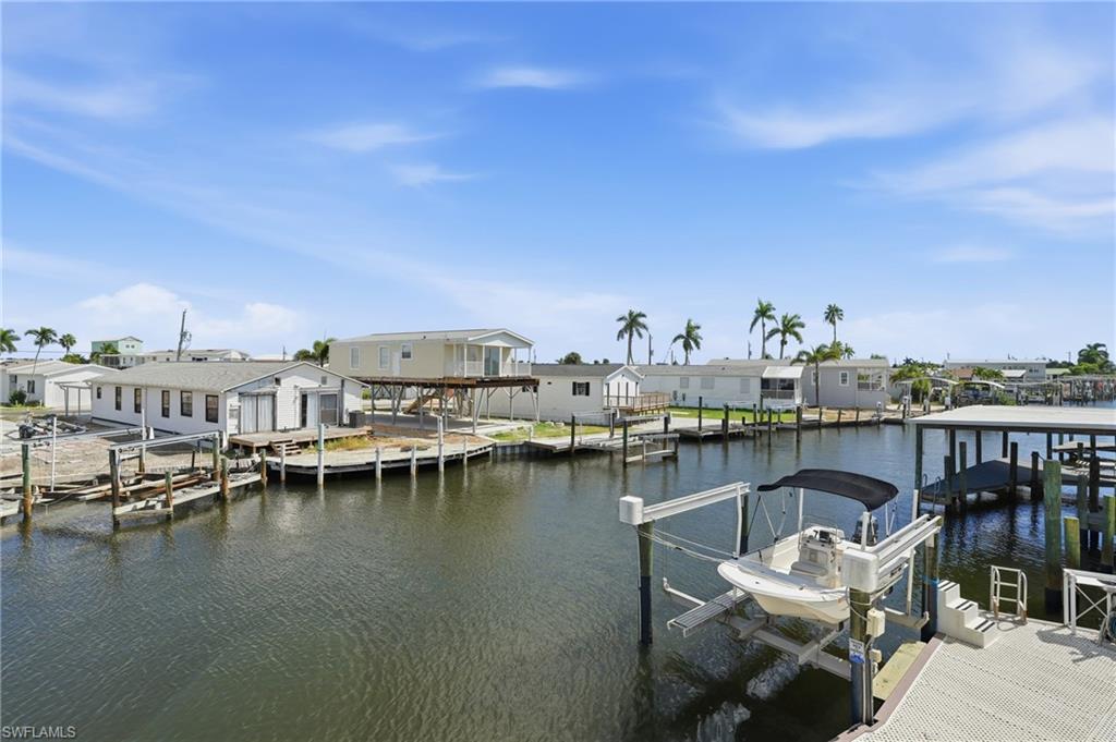Waterfront property featuring a private boat lift, a dock structure, and direct canal access