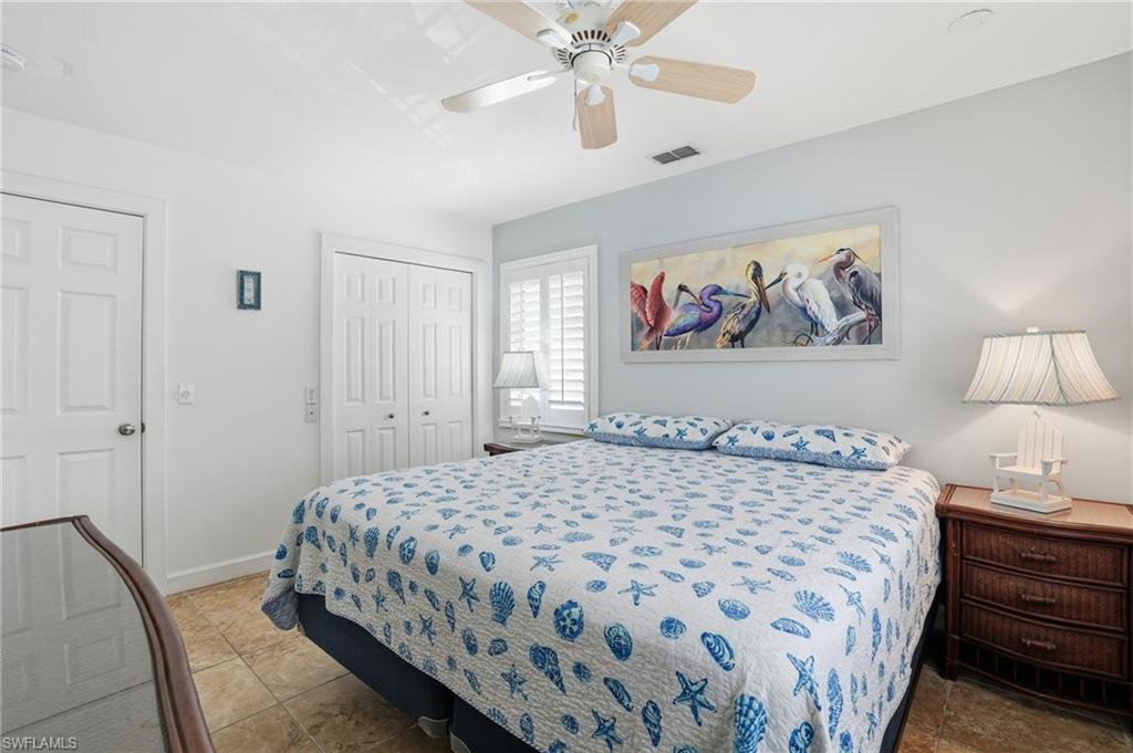 Tile flooring, white paneled doors, and a ceiling fan with light fixture