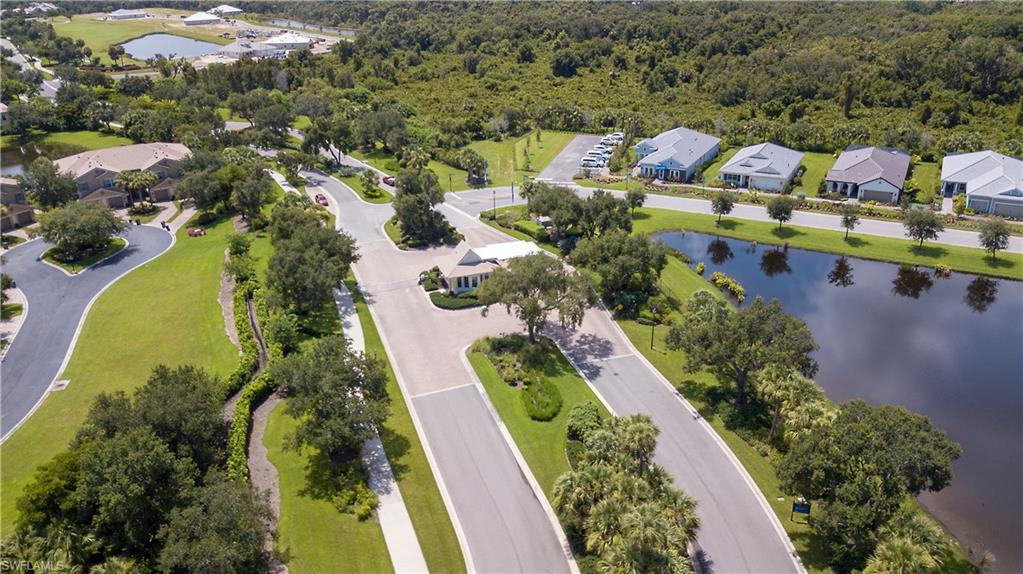 Aerial perspective showcasing a residential community with winding streets, multiple homes, and two distinct ponds