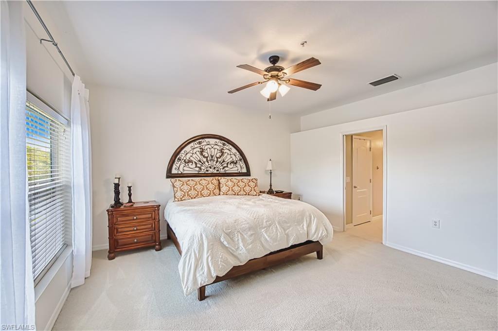 Carpeted bedroom with a window featuring blinds and white drapes