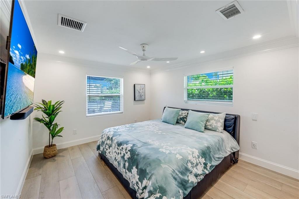 Guest Bedroom Bright room featuring light wood-finish flooring