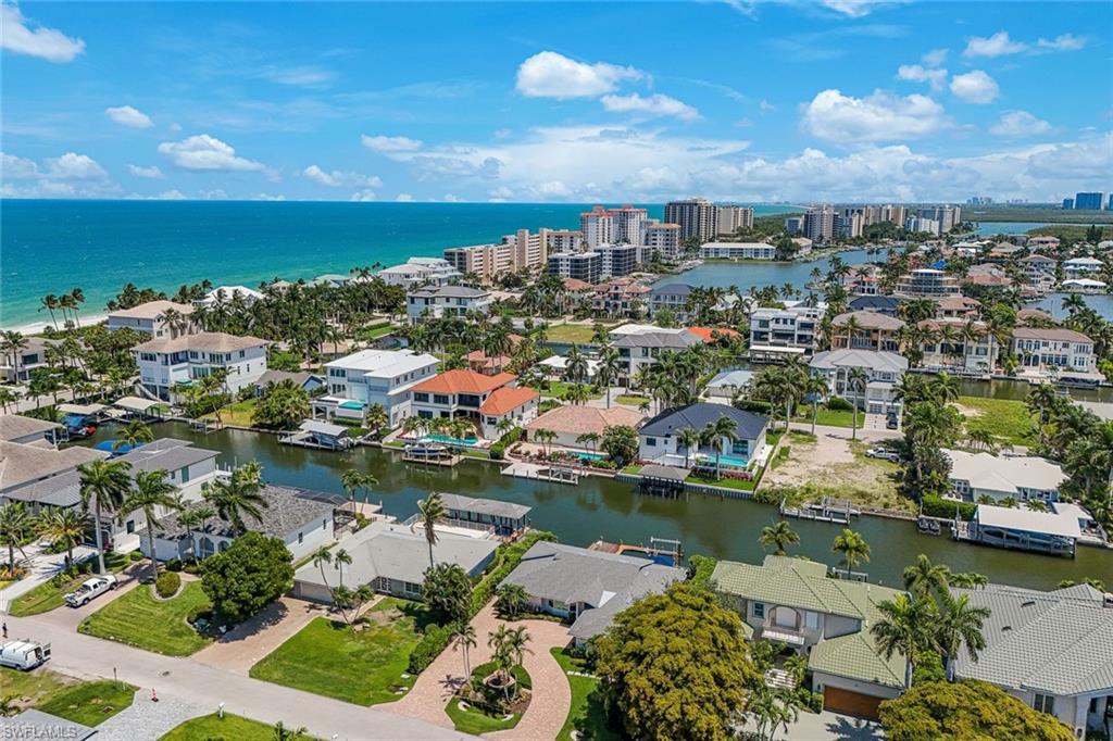 Aerial perspective showcasing a coastal community with numerous properties featuring private boat docks