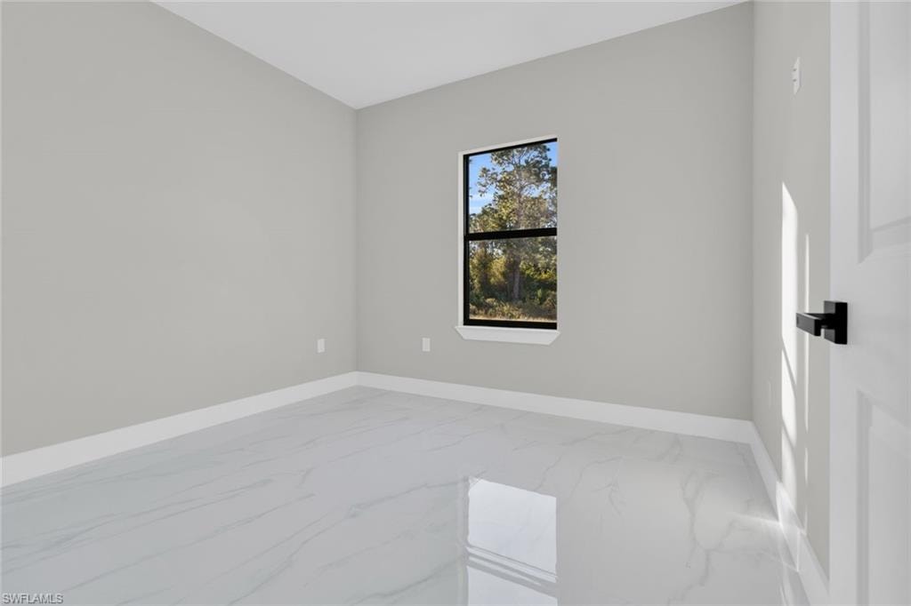 Neutral tone walls and white baseboards complement the polished marble-look tile flooring