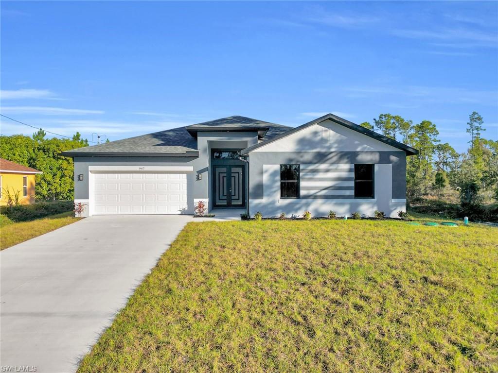 Contemporary single-story residence featuring a two-tone gray and white facade, a prominent entryway with a geometric-paneled door, and a two-car garage with a panel door