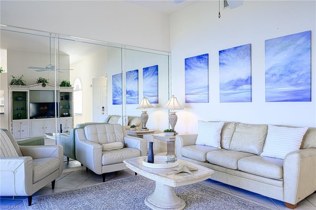 Living area with a ceiling fan and tile patterned flooring