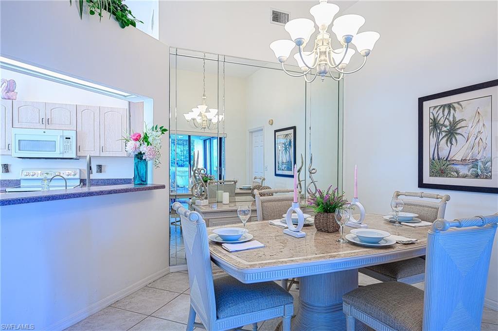 Dining space with a chandelier, a towering ceiling, and light tile patterned floors