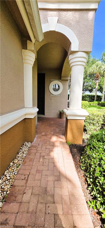 Covered entryway featuring decorative columns and an arched ceiling