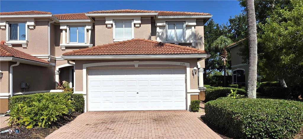 Stucco exterior with a tiled roof and white garage door