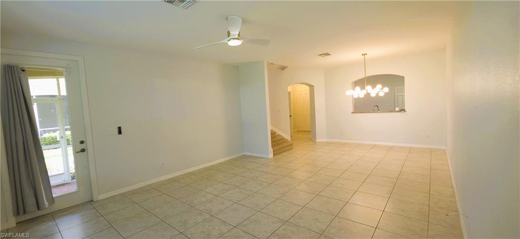 Expansive interior featuring tile flooring, a contemporary ceiling fan, and a modern chandelier