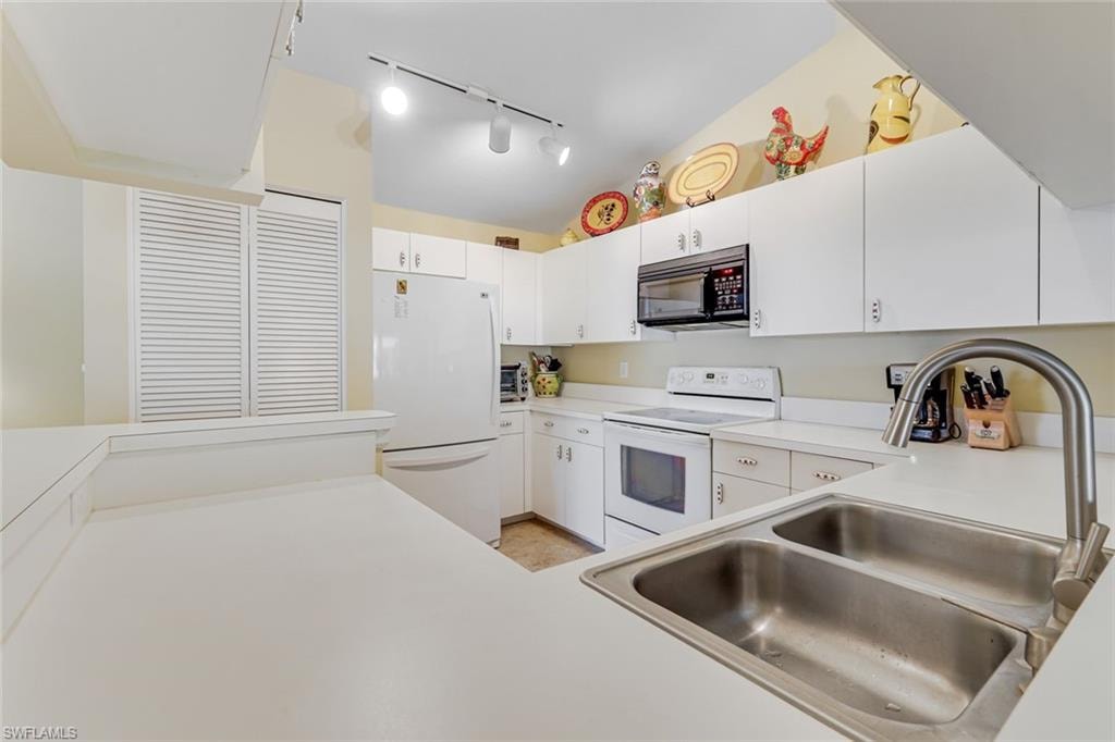 Kitchen with white cabinetry, a double basin stainless steel sink, and a high-arch faucet