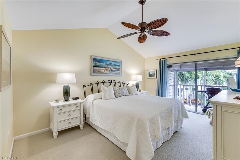 Vaulted ceiling bedroom featuring a ceiling fan, carpeted flooring, and direct access to an outdoor screened enclosure