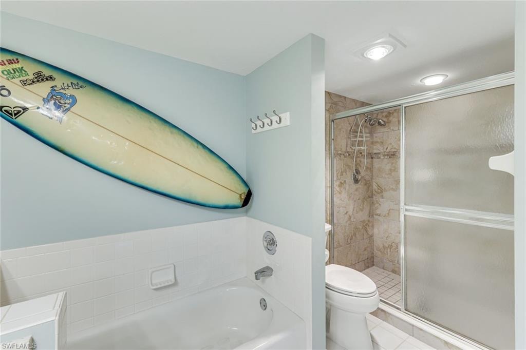 Bathroom featuring a bathtub with subway tile surround, tiled shower with sliding glass door, and recessed lighting