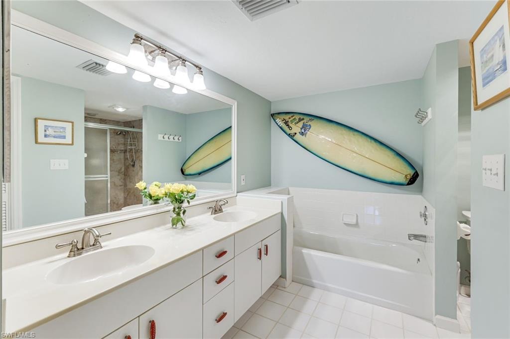 Bathroom featuring an extended double vanity with integrated sinks, brushed nickel faucets, and under-cabinet storage