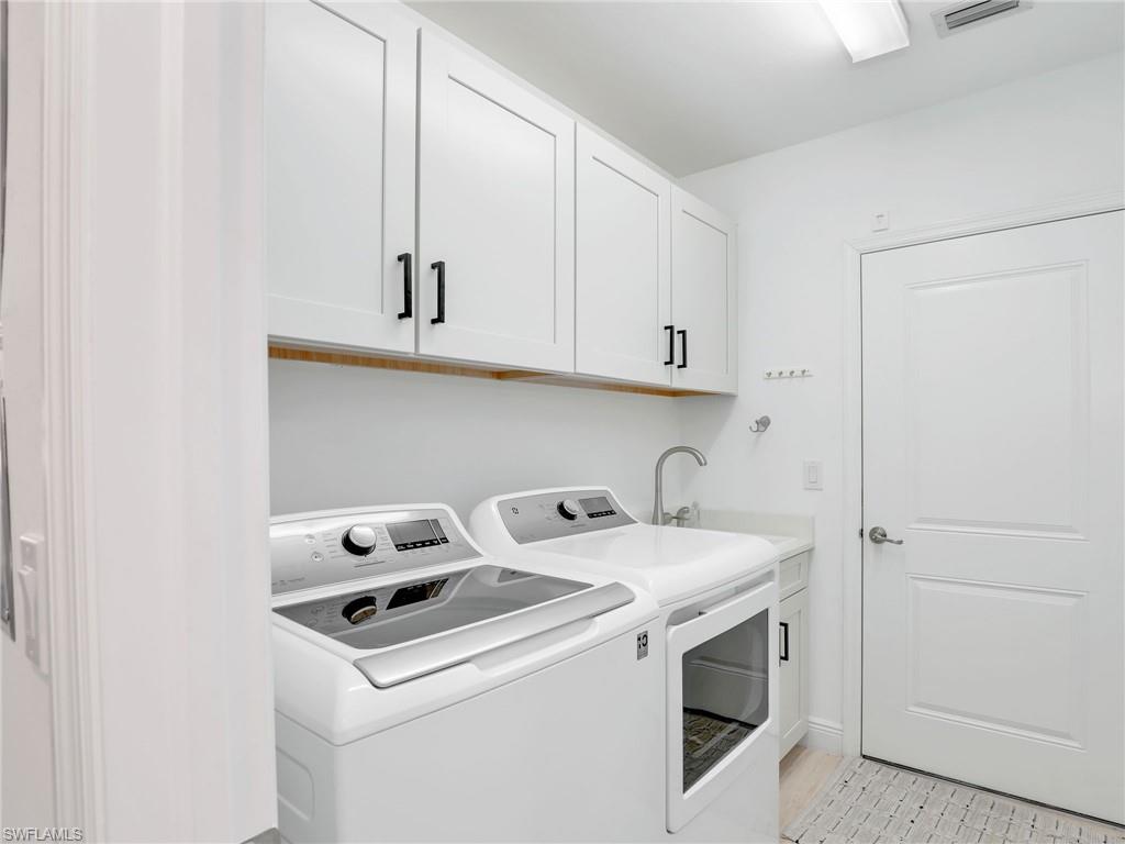 Laundry room with washer and clothes dryer and cabinet space