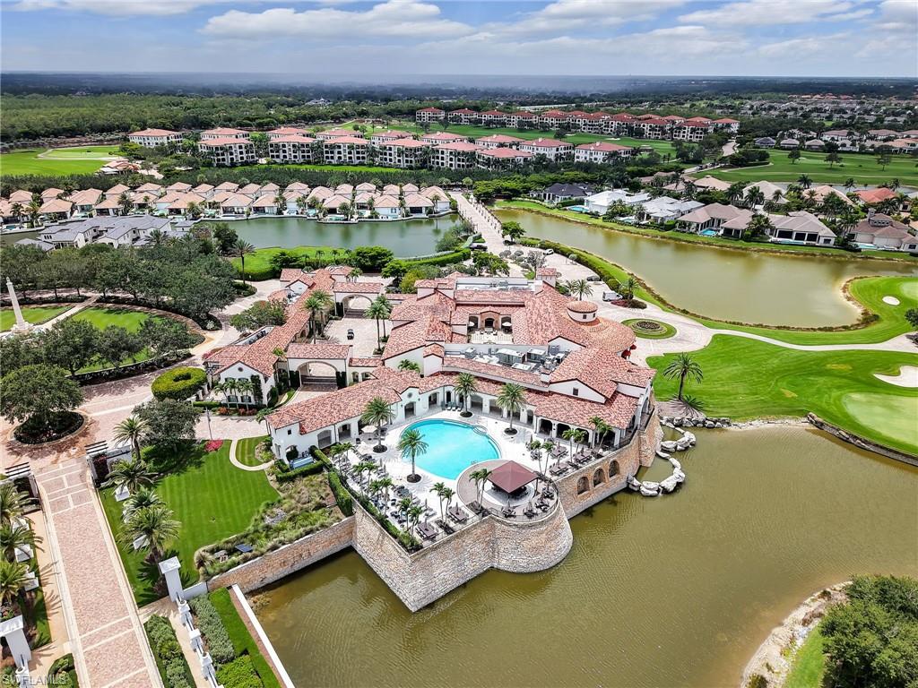 Aerial view of residential area with a large body of water, a golf course, and a pool area