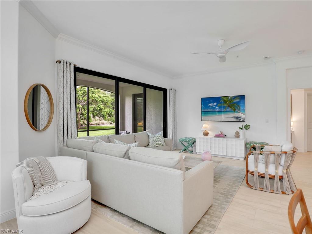 Living area with crown molding, a ceiling fan, and light wood-type flooring