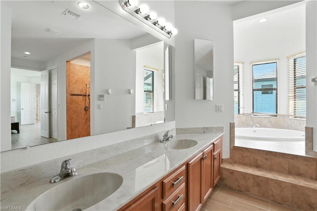 Bathroom featuring a double vanity with wood cabinetry and light-toned countertops