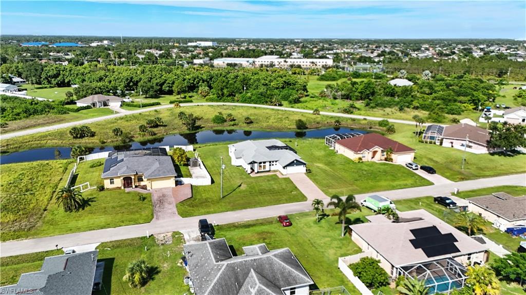 Aerial perspective showcasing multiple properties, residential streets, and a prominent canal