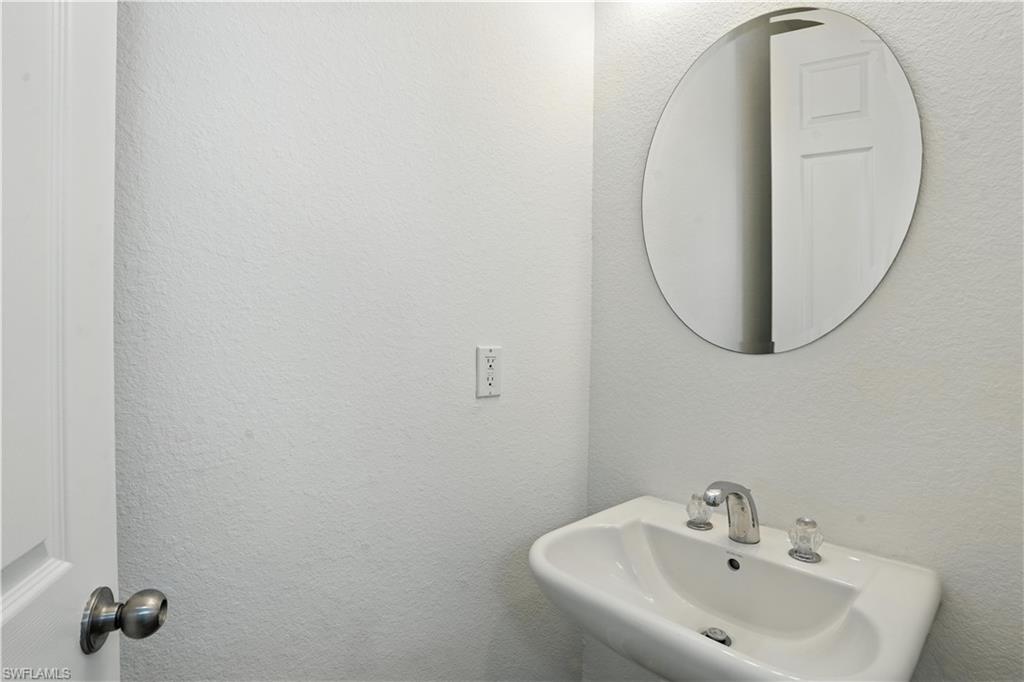 Pedestal sink with chrome faucet and clear acrylic handles