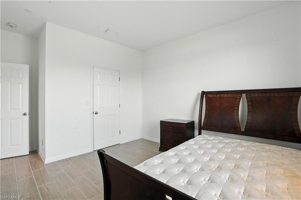 Spacious room featuring light-toned tile flooring, white walls, and white trim