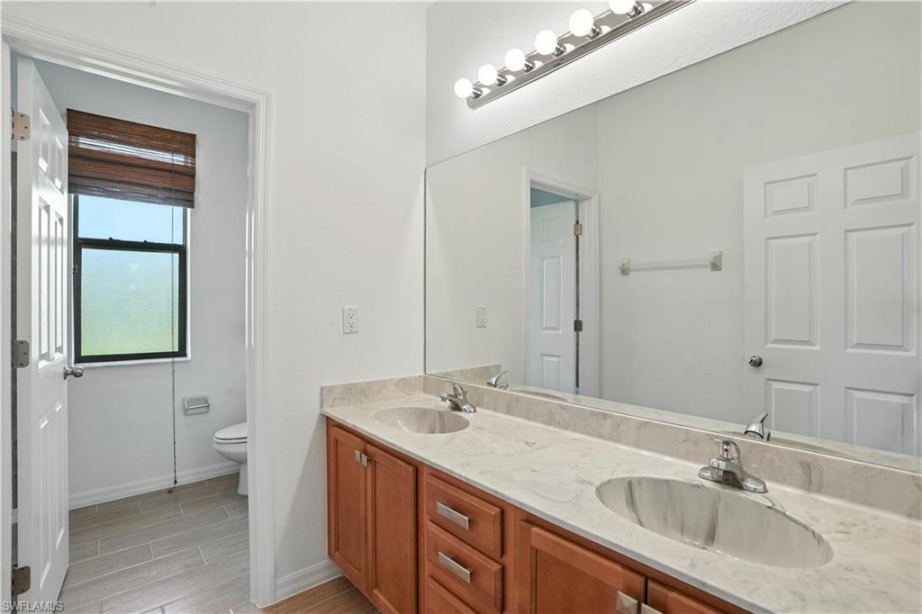 Dual vanity with integrated sinks, stone-finish countertop, and wood cabinetry
