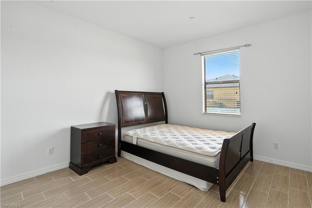 Bright room featuring light-toned tile flooring and a window with horizontal blinds