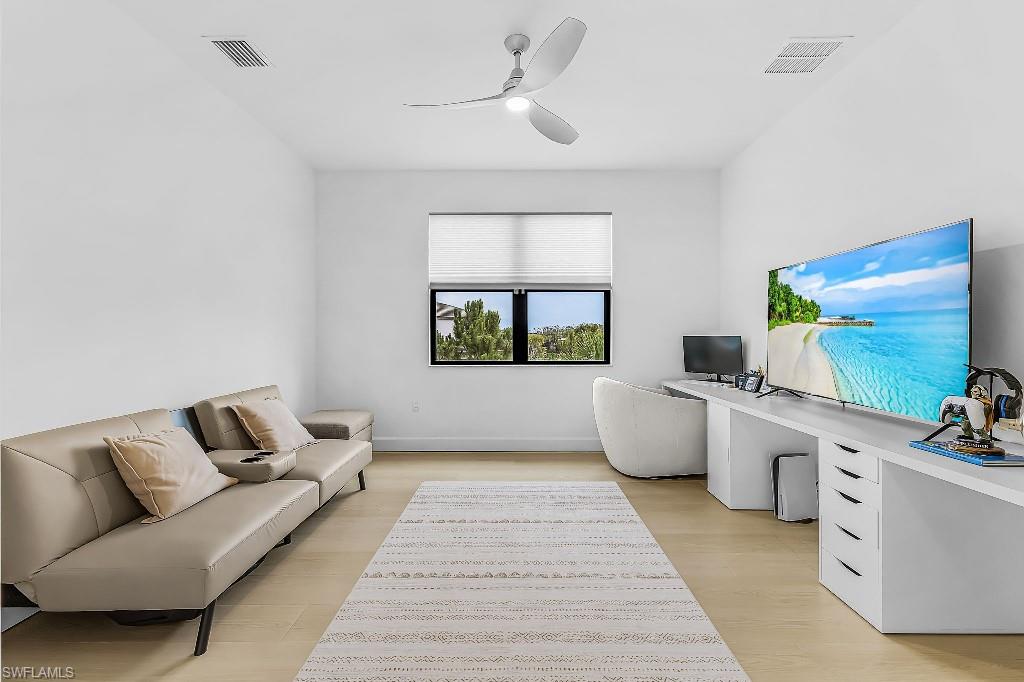Light-filled room featuring wood-finish flooring, a contemporary ceiling fan, and a window with blinds