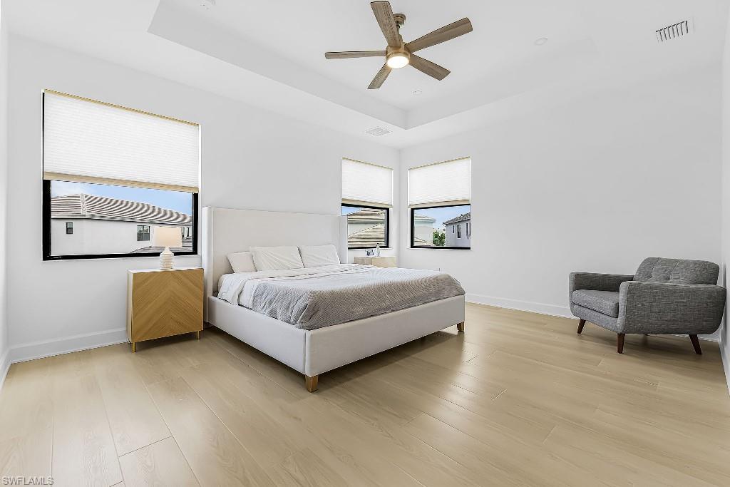 Spacious bedroom with light-toned wood-finish flooring