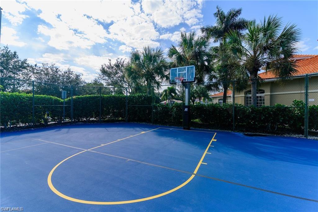 Outdoor basketball court with a blue playing surface and yellow court lines