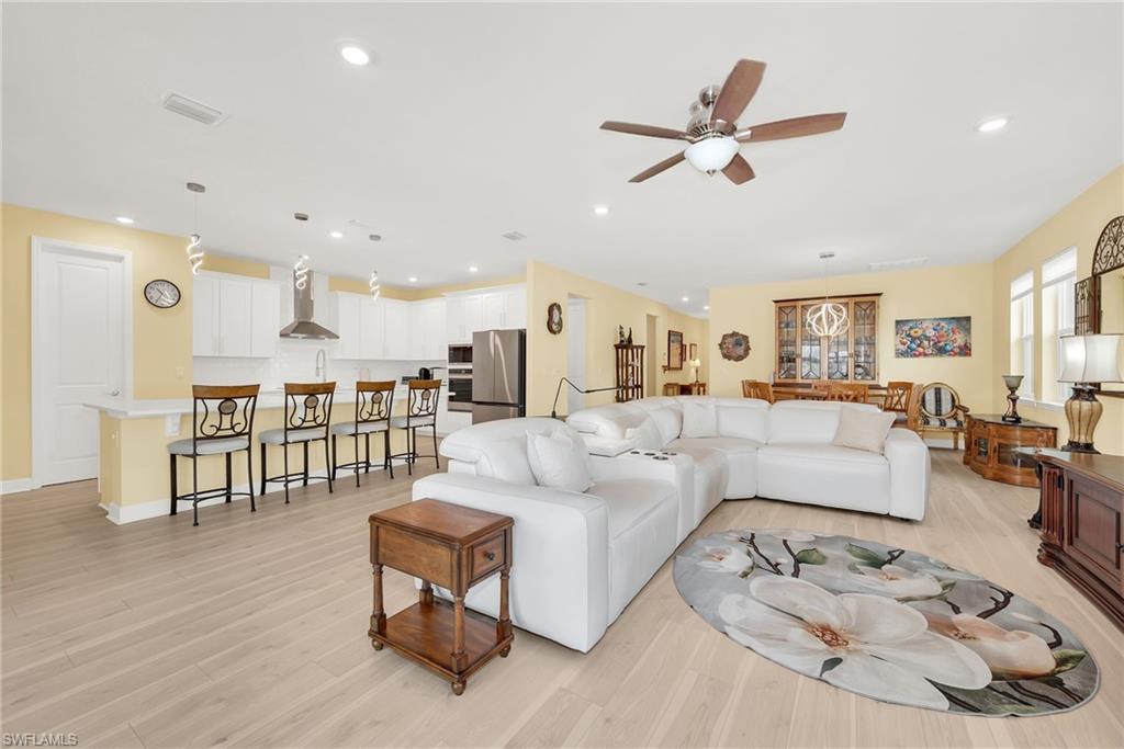Open-concept living space featuring wood-finish flooring, recessed lighting, and a ceiling fan