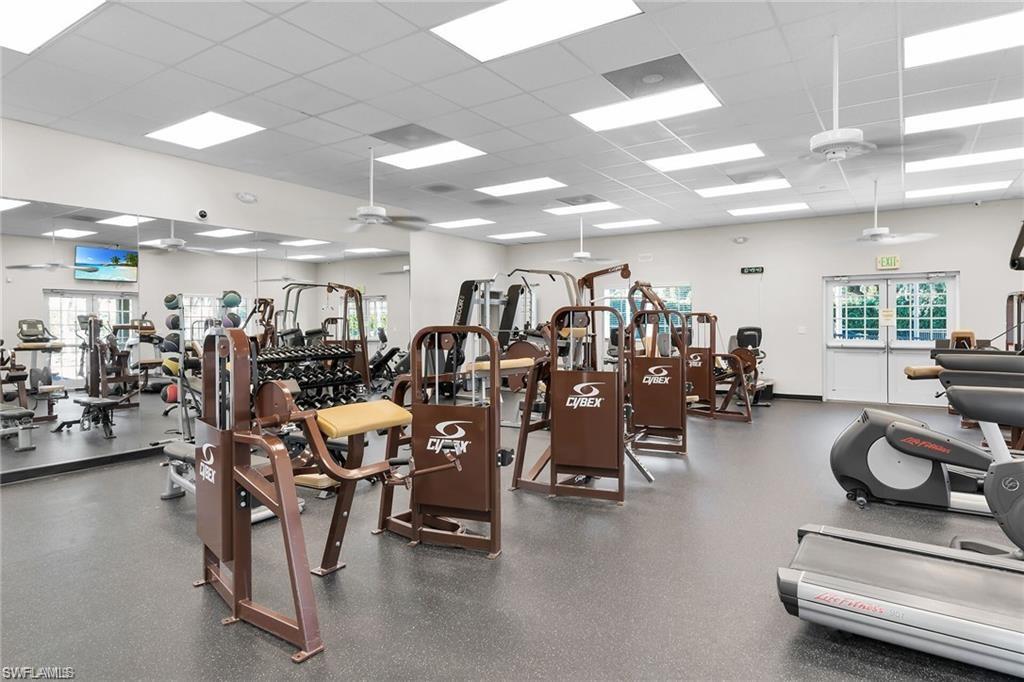 Fitness center featuring extensive exercise equipment, mirrored walls, recessed lighting, ceiling fans, and double-door exterior access