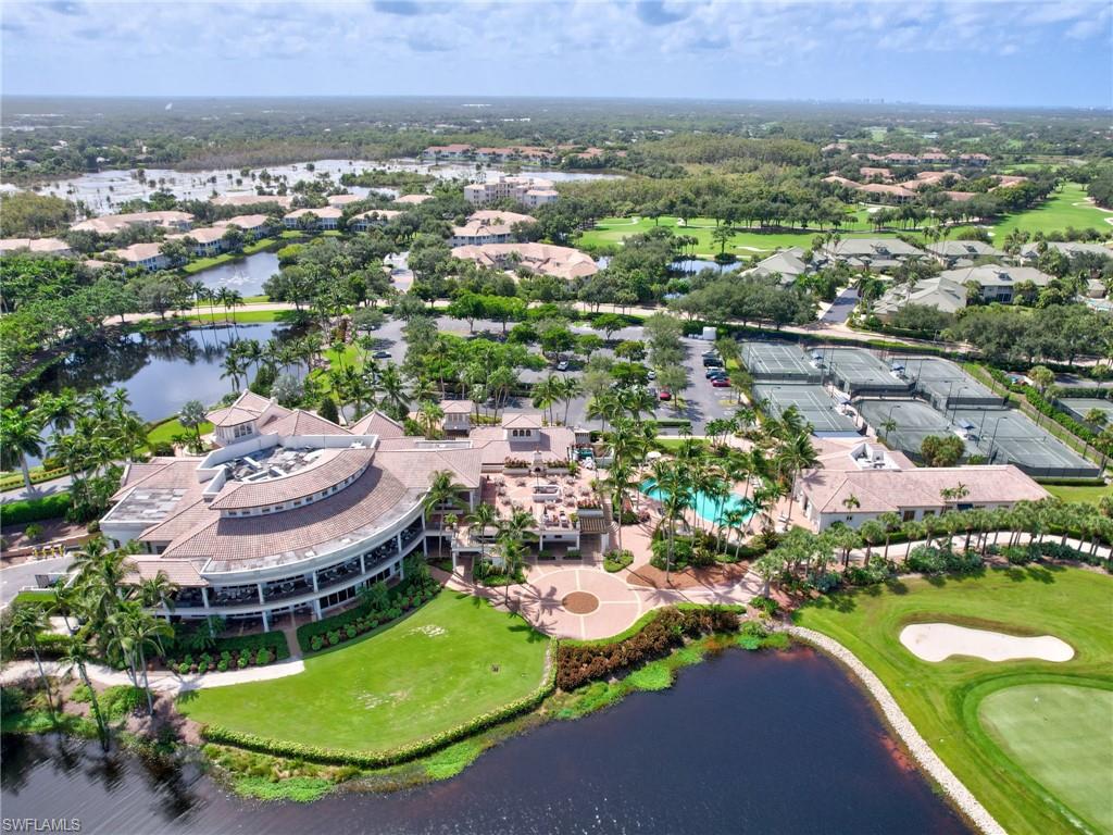 Expansive club facility featuring a curved building with multiple levels, extensive tennis courts, a large swimming pool, and surrounding green spaces