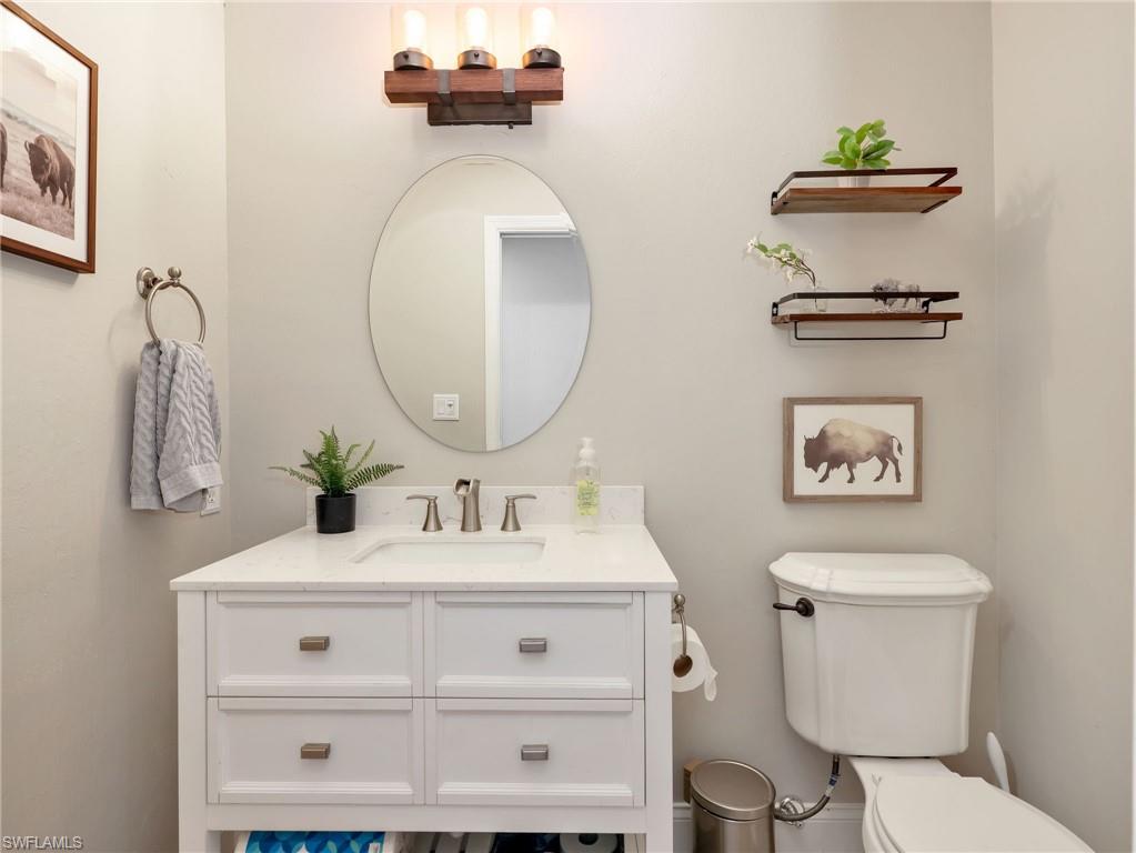 White vanity with integrated sink and brushed nickel faucet