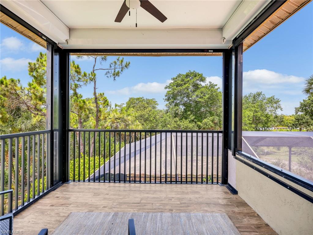 Screened balcony featuring wood-finish flooring and a ceiling fan