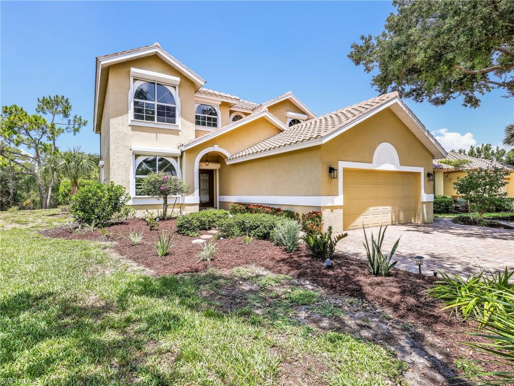 Stucco exterior featuring arched windows, a barrel tile roof, and an arched entry with a glass-paneled door